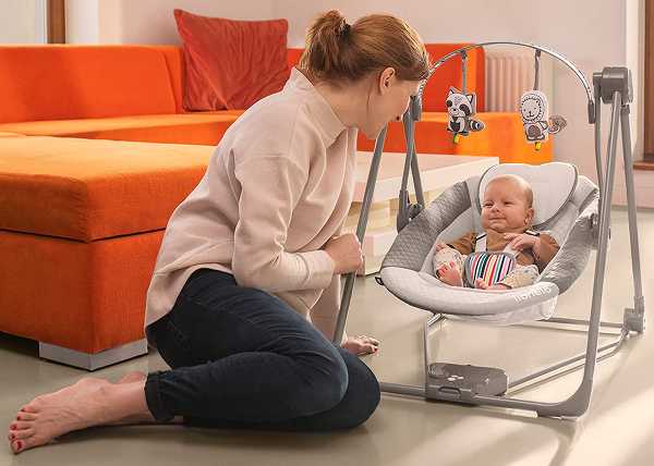 Mutter mit Kleinkind in einer elektrischen Babywippe